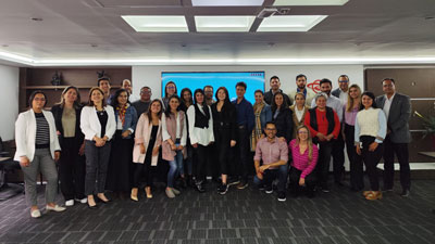 Equipo de Confianza posando para una foto grupal en una sala de conferencias. Todos están vestidos con ropa de trabajo formal y casual, y parecen estar en un entorno corporativo moderno