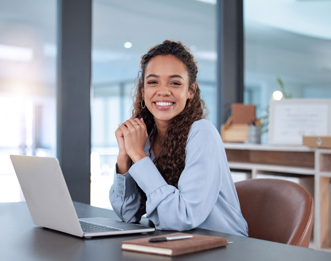 Mujer sonriendo con un computador portatil